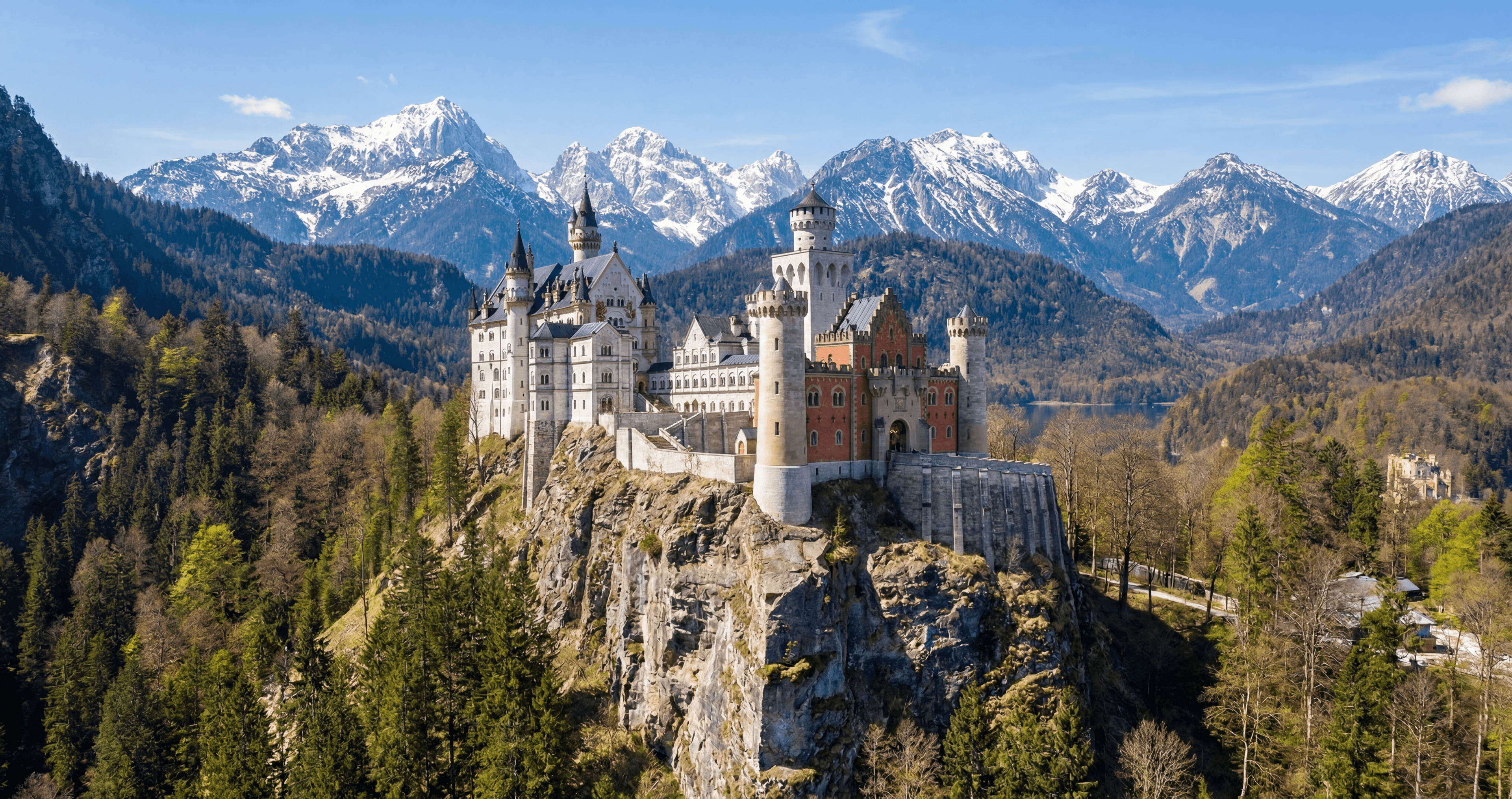 Castle on a forested ridge below snowy peaks, rendered with Rendershop
