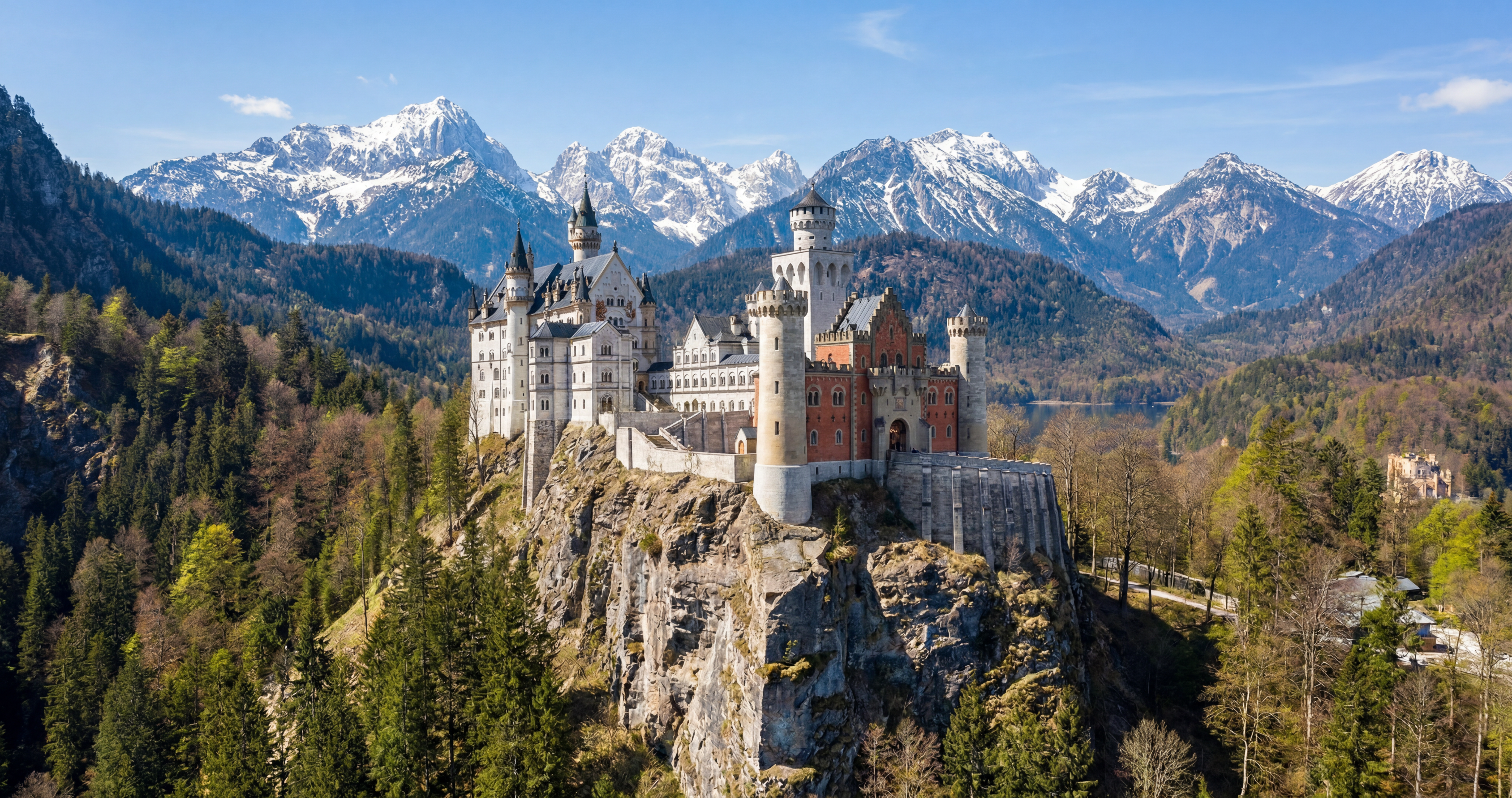 Castle on a forested ridge below snowy peaks, rendered with Rendershop